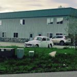 Commercial building exterior with parked vehicles and landscaping, relevant to recent property sales in Colorado.