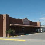 Southwestern-style commercial building with earth-toned facade and business sign for Rocky Mountain Real Estate.