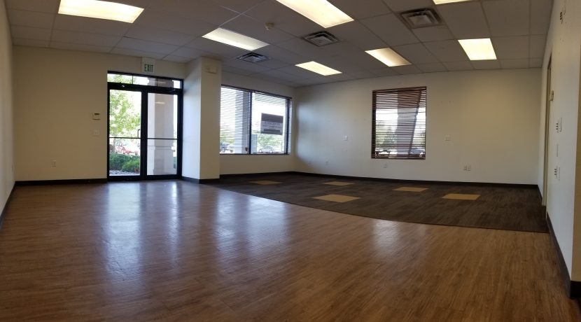 Interior view of a retail space for lease in Valley View Plaza, featuring wooden flooring, large windows, and natural light, suitable for various commercial uses.