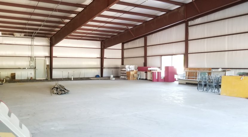 Interior view of a spacious retail unit in Valley View Plaza, showcasing high ceilings, metal framework, and unfinished areas suitable for tenant customization.