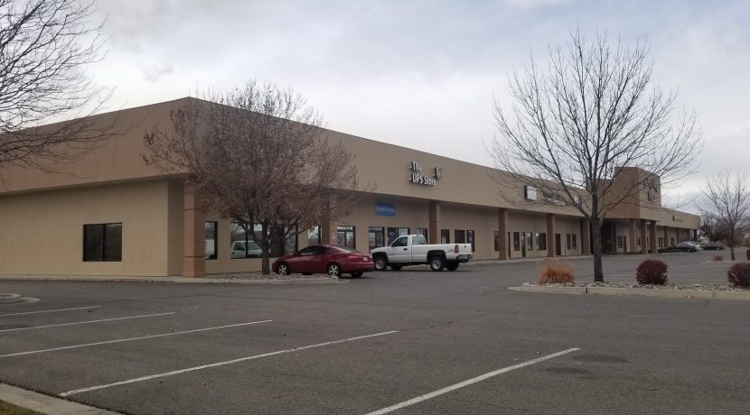 Retail center exterior view at Valley View Plaza, featuring The UPS Store, parking lot, and surrounding trees, located in Delta, CO, for lease opportunities.