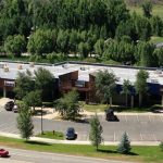 Modern office complex with flat roof, large windows, and greenery near BLM headquarters in Grand Junction, Colorado.