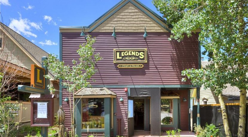 Restaurant building exterior in Breckenridge, CO, featuring "Legends" signage, surrounded by trees and showcasing a welcoming entrance, ideal for a turn-key commercial property listing.