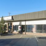 Single-story commercial building with large windows and green exterior, located in Aspen/Snowmass for real estate insights.