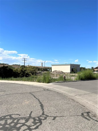Commercial lots at TBD Lot 7 & 8 Hawk Parkway, Montrose, with surrounding greenery and industrial building, in a prime location for business development.