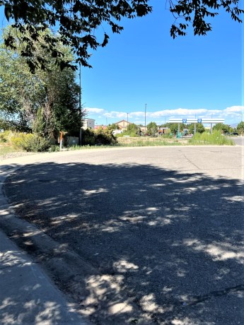 Curved road at TBD Lot 7 & 8 Hawk Parkway, surrounded by greenery and signage, near commercial area in Montrose, Colorado.