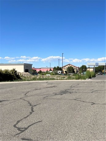Commercial lots for sale at TBD Lot 7 & 8 Hawk Parkway, Montrose, featuring nearby businesses and open space, highlighting the potential for development in a high-traffic area.