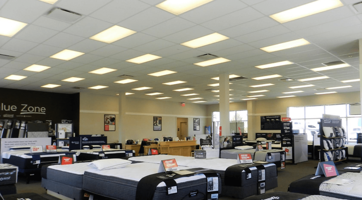 Showroom interior displaying various mattresses and bedding products, with promotional signage, bright lighting, and a spacious layout, relevant to commercial retail space for sale at 3501 Wolverine Dr, Montrose, Colorado.