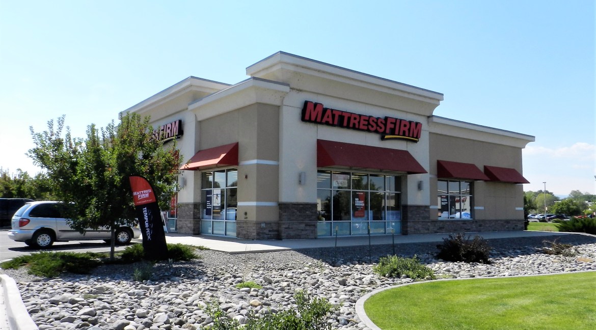 Commercial retail building exterior featuring Mattress Firm signage, landscaped lot, and ample parking, located at 3501 Wolverine Dr, Montrose, Colorado.