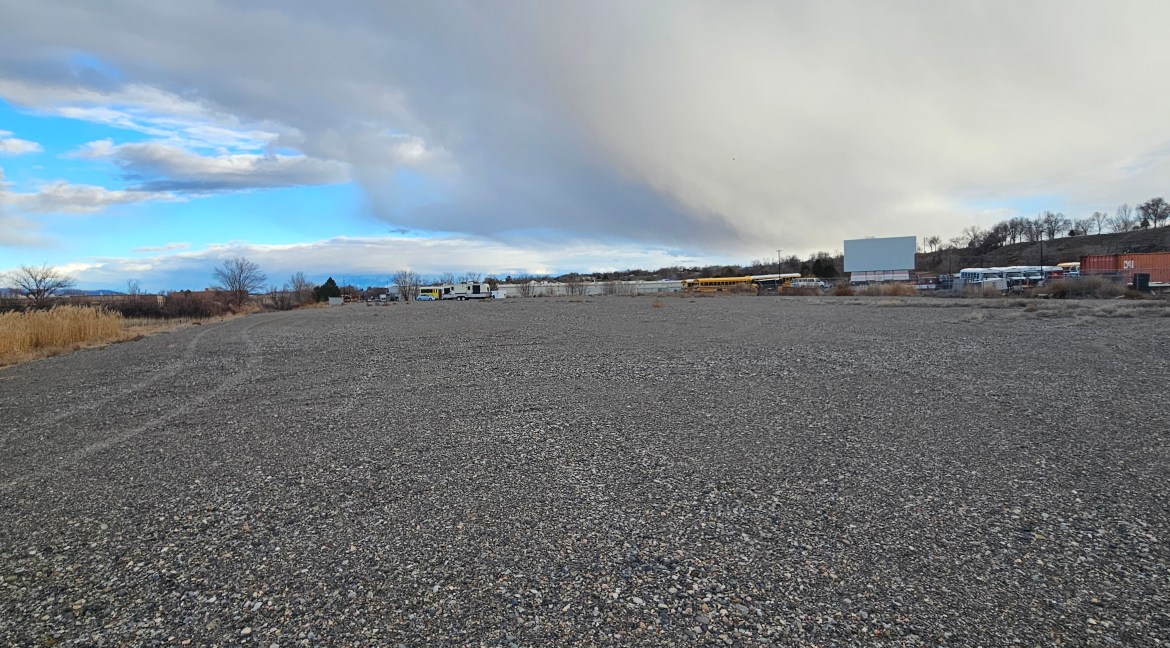 4.34-acre commercial land parcel with B-3 zoning, featuring gravel terrain, adjacent to commercial properties in Delta, Colorado.