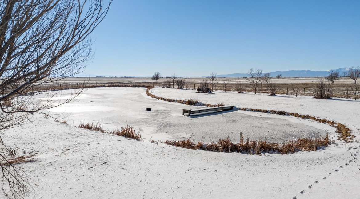 JEB Ranch aerial of pond at main residence and mountain views