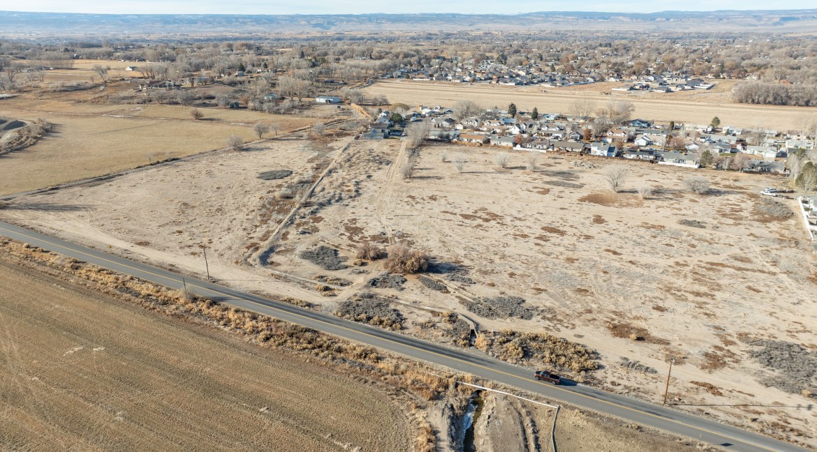 Aerial view of 14.84-acre residential development land near TBD G Road, Delta, Colorado, showcasing proximity to nearby residential areas and open fields.