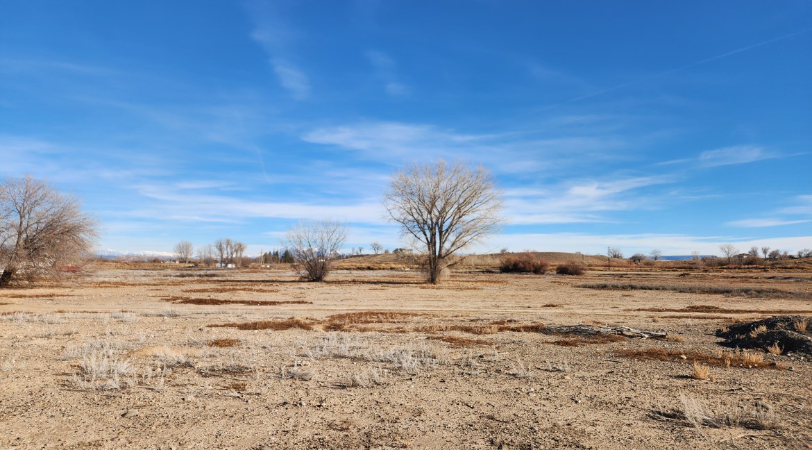 Residential development land with sparse vegetation and trees, located near TBD G Road, Delta, CO, showcasing a turn-key opportunity for investors.