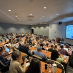Audience in a lecture hall with laptops, engaged in a Rocky Mountain Commercial Real Estate presentation.