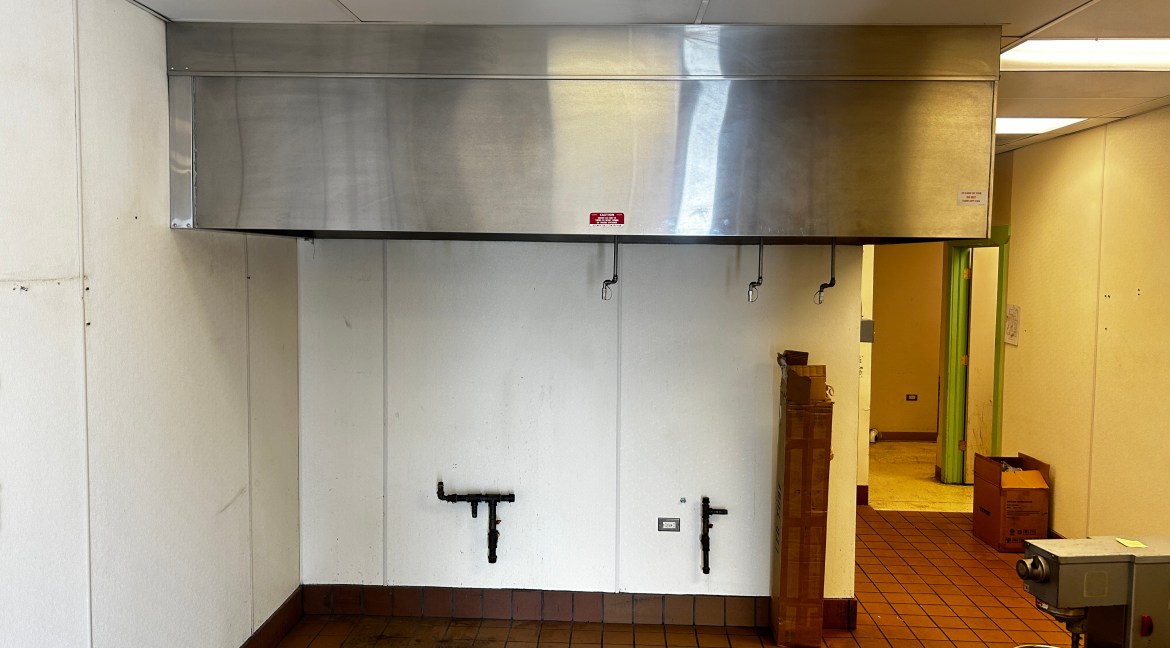 Commercial kitchen hood installation with wall-mounted plumbing fixtures in a lease-ready space at 350 Stafford Lane, Delta, Colorado.